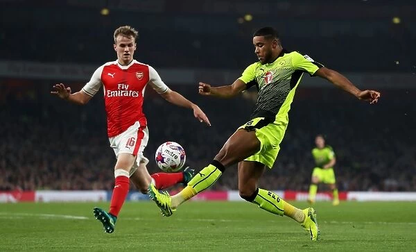 Holding Off Samuel: Intense Battle for the Ball in Arsenal vs. Reading EFL Cup Clash