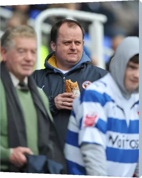 A Reading fan enjoys a bite to eat in the stands prior to kick off