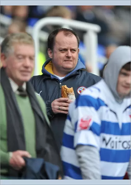 A Reading fan enjoys a bite to eat in the stands prior to kick off