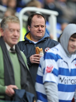 A Reading fan enjoys a bite to eat in the stands prior to kick off